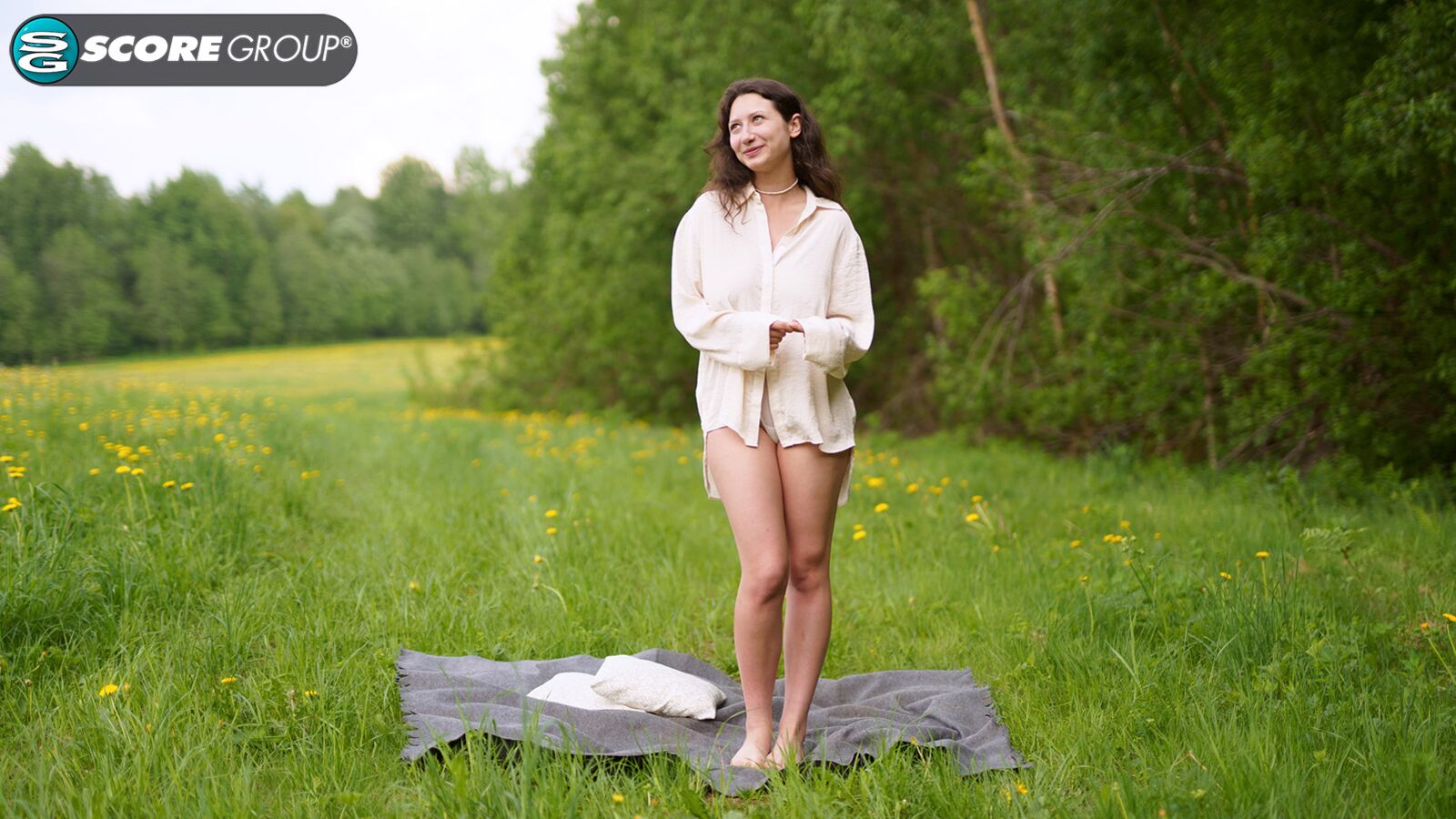 Busty teenage brunette Lola exposes her DD-cup tits in an open field and spreads her pussy for your pleasure.