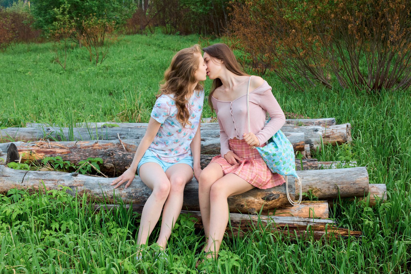 Excited cuties give cunnilinguses in the meadow